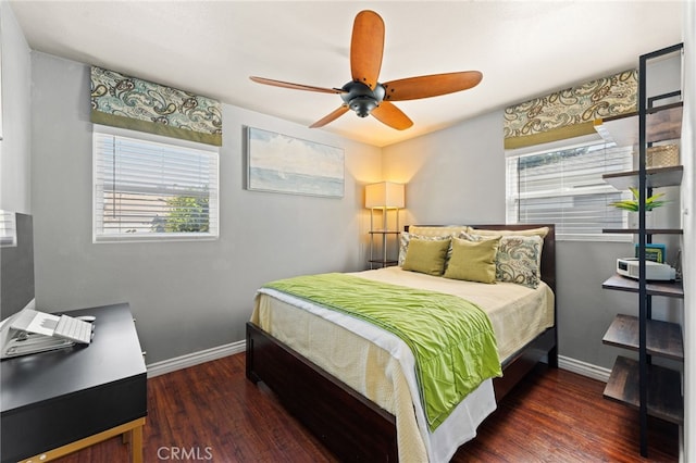 bedroom featuring multiple windows, ceiling fan, and dark hardwood / wood-style flooring