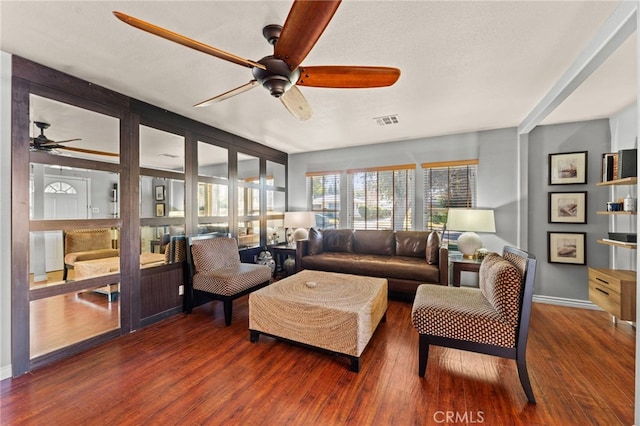 living room featuring dark hardwood / wood-style flooring, a textured ceiling, and ceiling fan