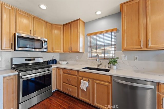 kitchen featuring dark hardwood / wood-style flooring, sink, stainless steel appliances, and light stone countertops