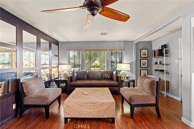 living room with dark wood-type flooring and ceiling fan