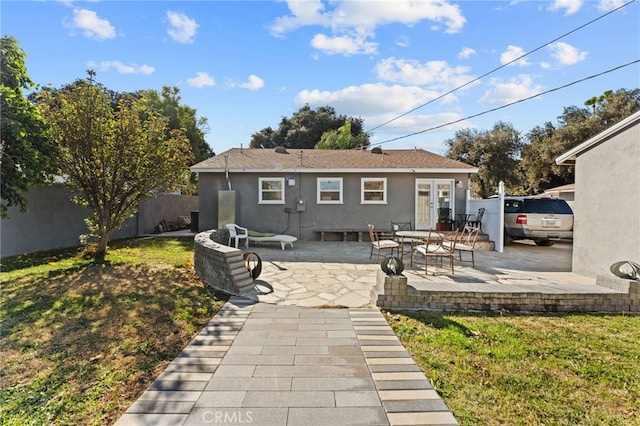 back of property with a patio and a lawn