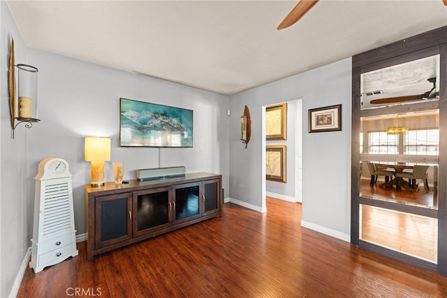 living room featuring dark hardwood / wood-style flooring and ceiling fan