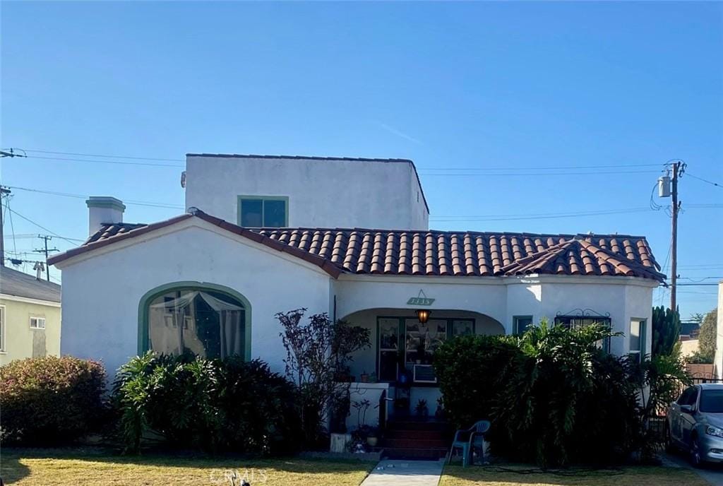 mediterranean / spanish home with a front lawn