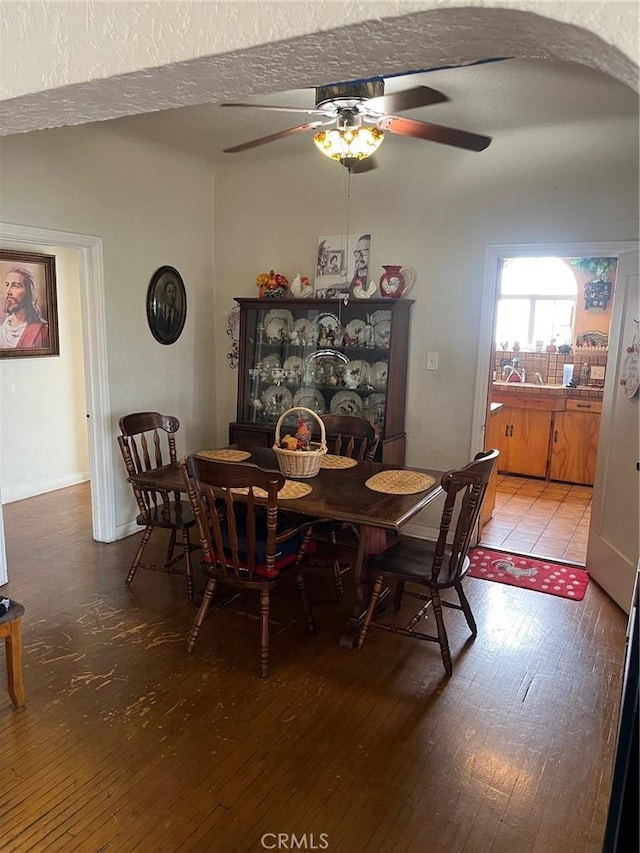 dining space with wood-type flooring and ceiling fan