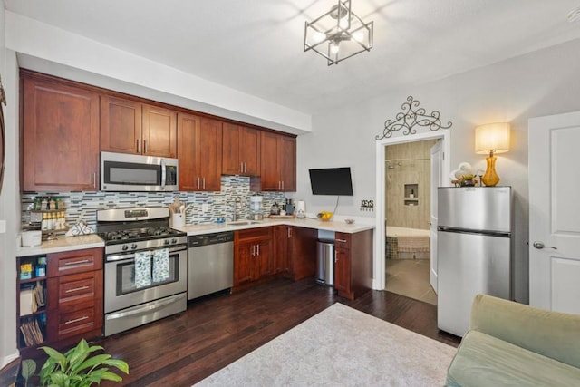 kitchen featuring appliances with stainless steel finishes, dark hardwood / wood-style floors, and decorative backsplash