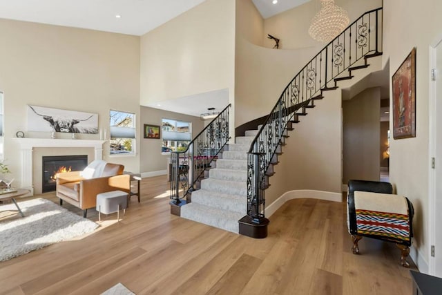 stairs with hardwood / wood-style flooring and a high ceiling