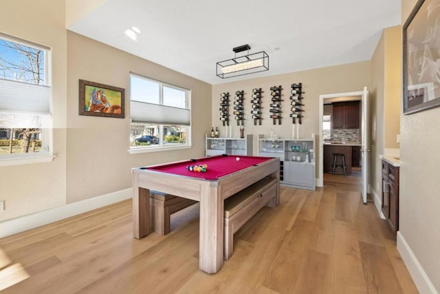 playroom with pool table, light hardwood / wood-style flooring, and indoor bar