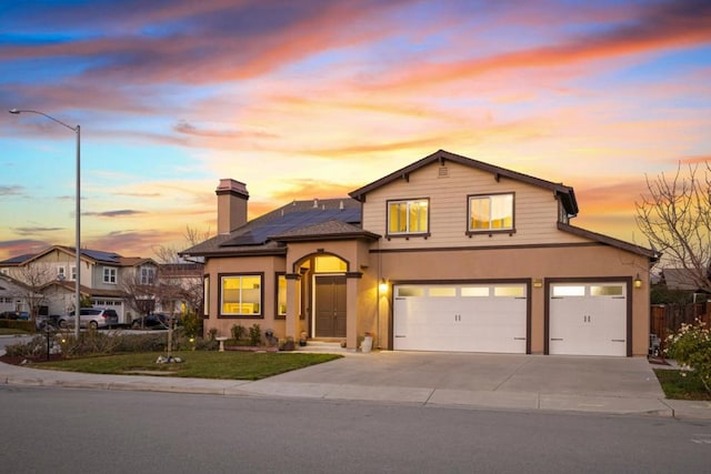 view of front of house with a garage and solar panels