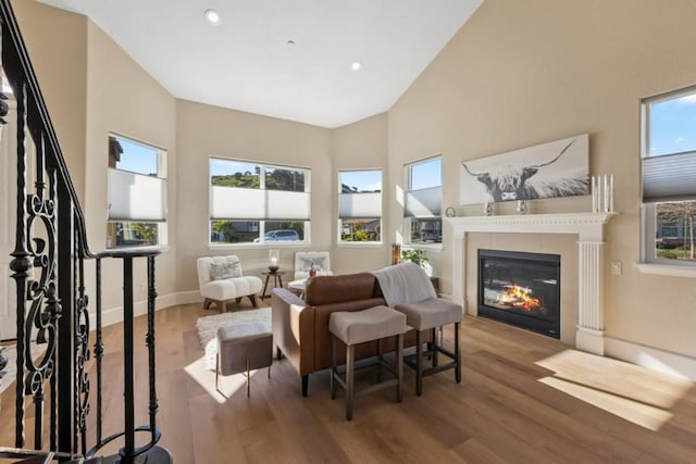 living area featuring hardwood / wood-style flooring, plenty of natural light, and high vaulted ceiling