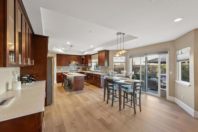 kitchen featuring pendant lighting, a center island, a breakfast bar area, and a tray ceiling