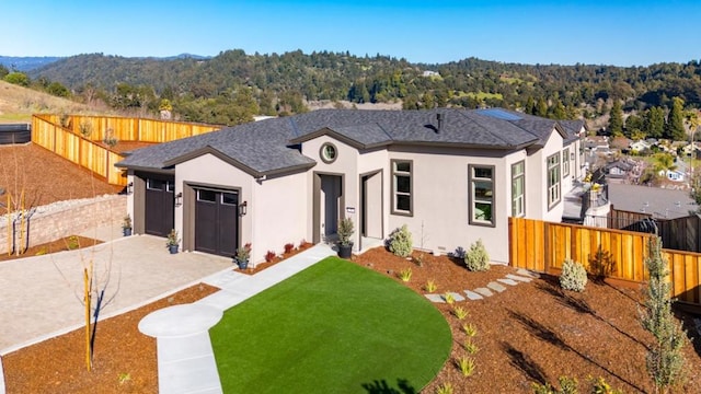 view of front of property featuring a garage, a front yard, and cooling unit