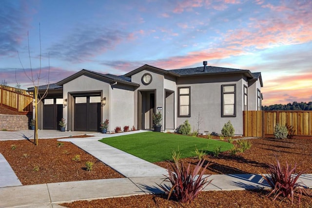 view of front of home with a garage and a lawn