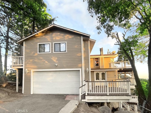 back of property with a balcony and a garage