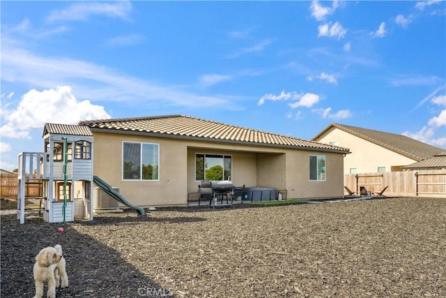 rear view of property with a playground