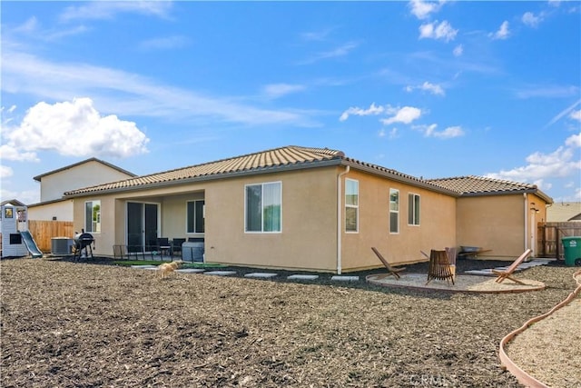 back of property with cooling unit and an outdoor fire pit