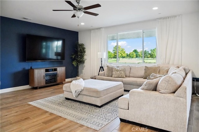 living room with wood-type flooring and ceiling fan