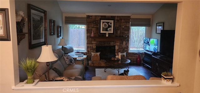 living room featuring plenty of natural light and a stone fireplace