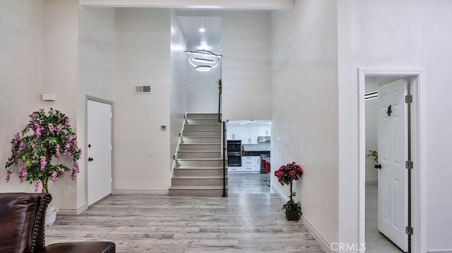 entryway featuring a high ceiling and light hardwood / wood-style floors