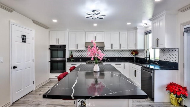 kitchen with sink, white cabinetry, double oven, a center island, and black dishwasher