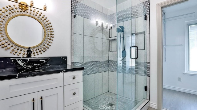 bathroom with vanity, hardwood / wood-style flooring, and a shower with shower door