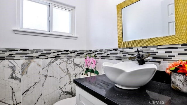 bathroom featuring vanity, tile walls, and backsplash