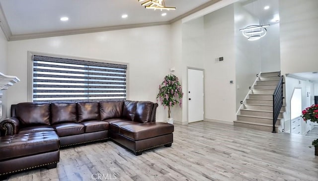 living room with crown molding, light hardwood / wood-style flooring, and vaulted ceiling