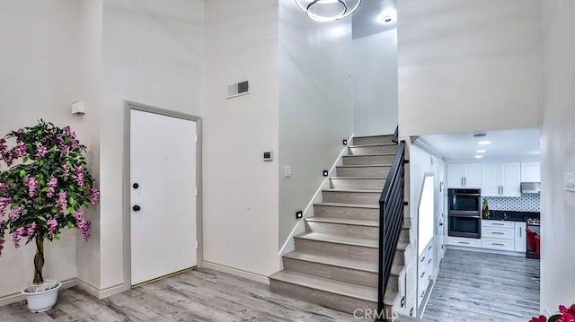 stairway featuring hardwood / wood-style flooring and a towering ceiling