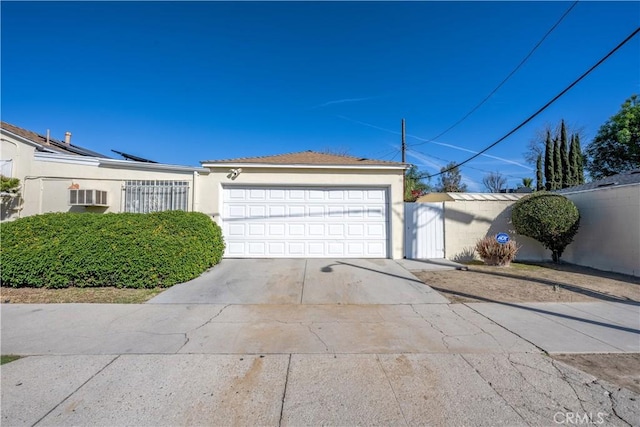 exterior space with concrete driveway, an attached garage, and stucco siding