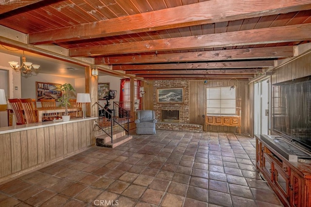 basement featuring a fireplace, wooden ceiling, and an inviting chandelier