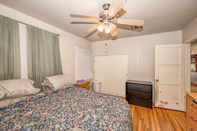 bedroom with wood finished floors, visible vents, and a ceiling fan
