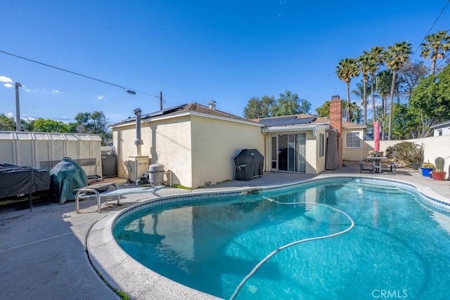 view of pool featuring a grill, a fenced backyard, a fenced in pool, and a patio