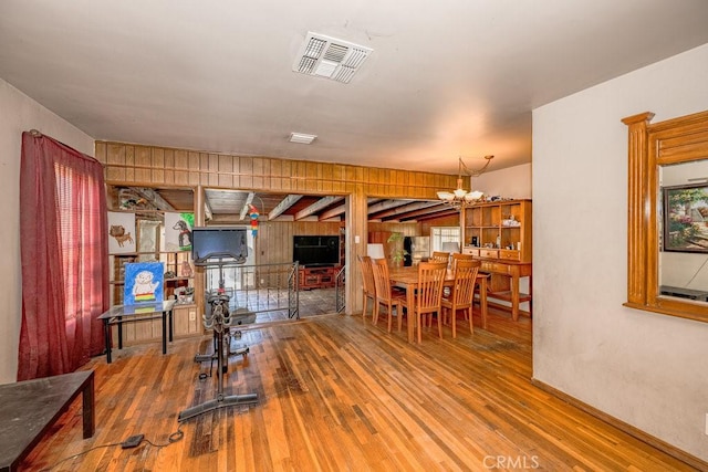 dining space with visible vents, an inviting chandelier, and hardwood / wood-style flooring