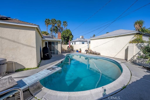 view of swimming pool with a fenced backyard, a fenced in pool, and a patio