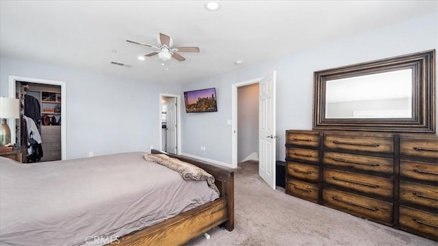 carpeted bedroom featuring visible vents, baseboards, a closet, a spacious closet, and ceiling fan