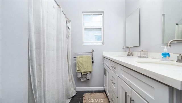 full bath with curtained shower, double vanity, a sink, and baseboards