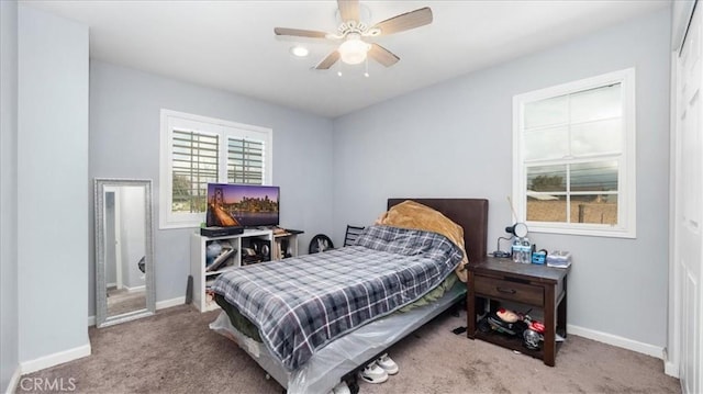 carpeted bedroom featuring baseboards and ceiling fan