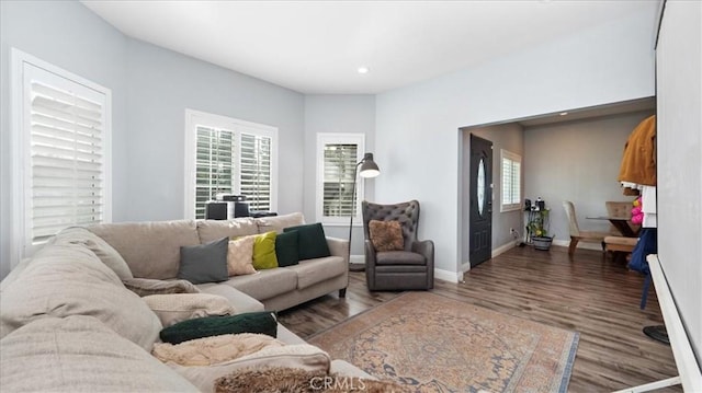 living room with recessed lighting, baseboards, and wood finished floors