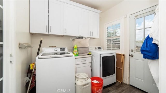 laundry area featuring washing machine and dryer, dark wood-style floors, and cabinet space