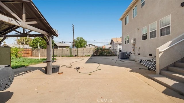 view of patio / terrace featuring a residential view, central AC, and fence