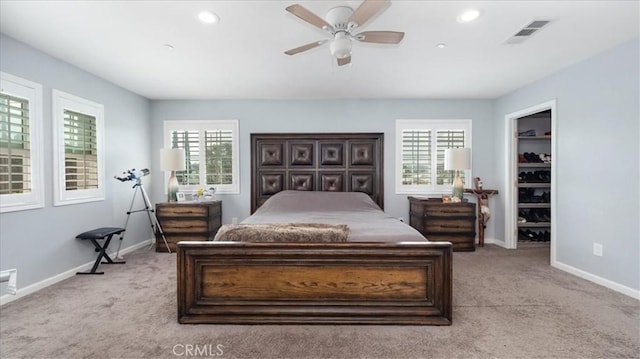 bedroom featuring visible vents, light colored carpet, baseboards, and ceiling fan