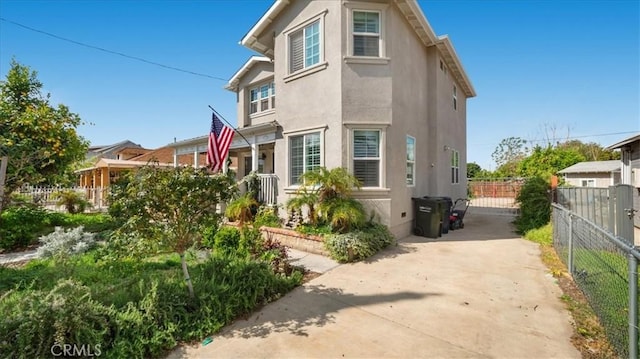 exterior space featuring stucco siding and fence