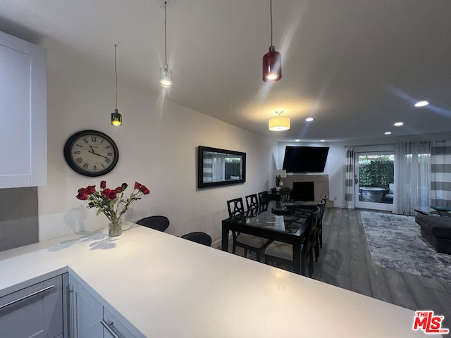 kitchen with pendant lighting, white cabinetry, and dark hardwood / wood-style floors