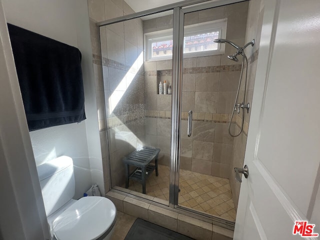 bathroom with toilet and a shower with shower door