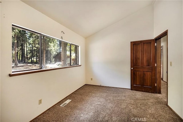 empty room with lofted ceiling and carpet floors