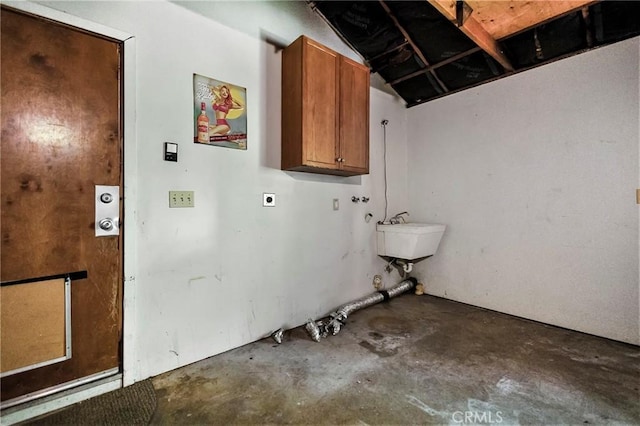 laundry room featuring electric dryer hookup, sink, and cabinets