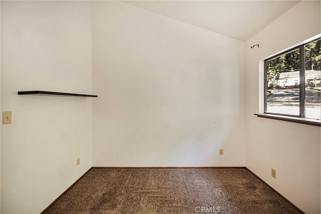 carpeted empty room featuring vaulted ceiling