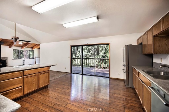 kitchen featuring vaulted ceiling, appliances with stainless steel finishes, sink, and dark wood-type flooring