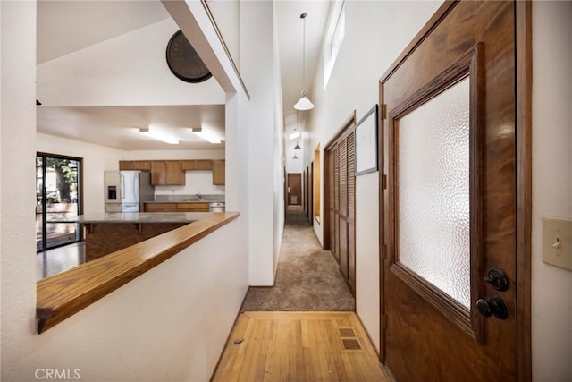 hallway with sink and light hardwood / wood-style flooring