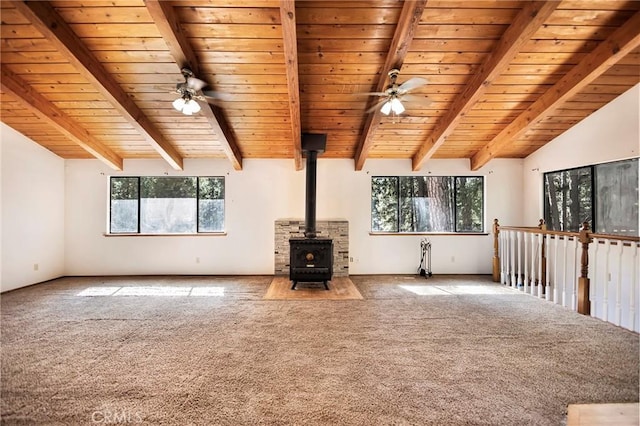 unfurnished living room with wood ceiling, ceiling fan, carpet, and a wood stove