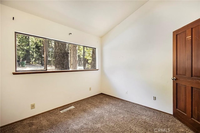 carpeted empty room with lofted ceiling